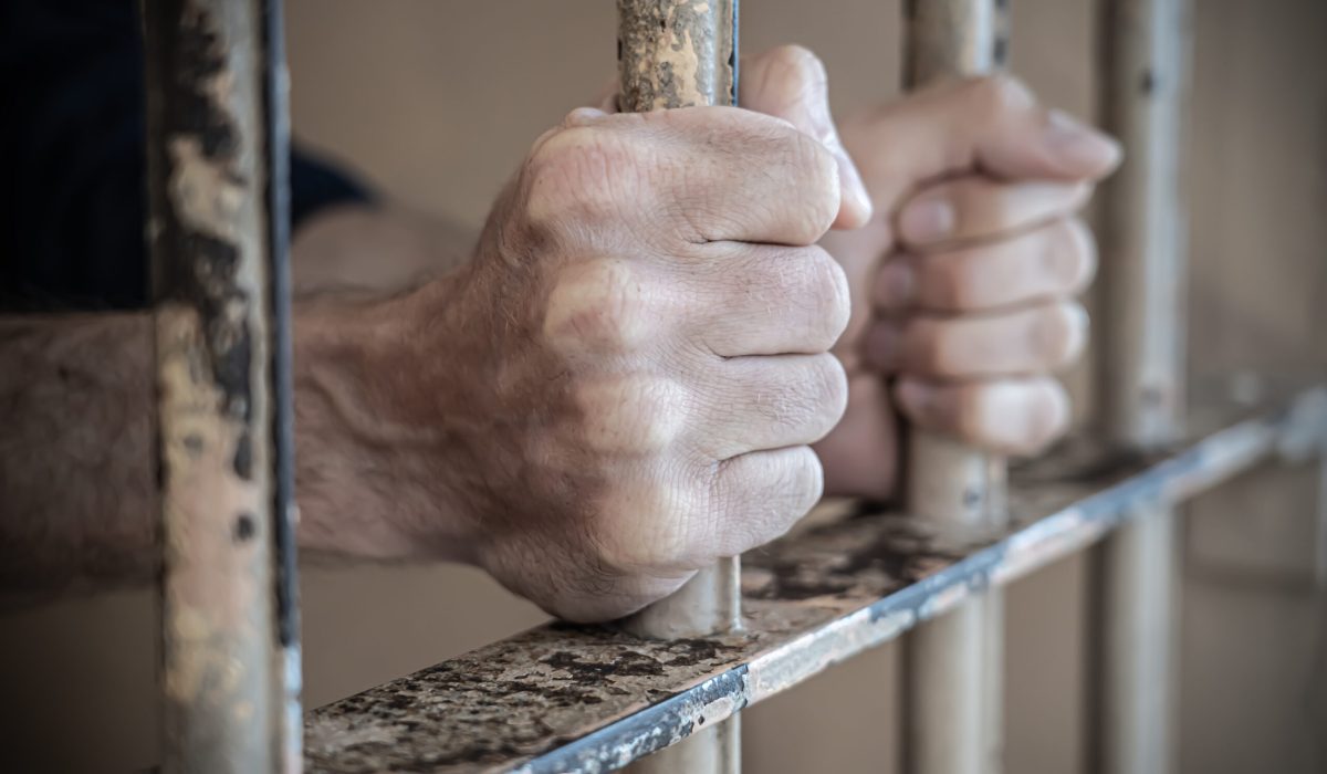 Close up of prisoner hands in jail.